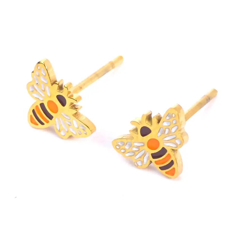 Angled view of bee stud earrings by Michelle Stephen, featuring white enamel wings and orange-striped bodies on sleek gold-plated posts.