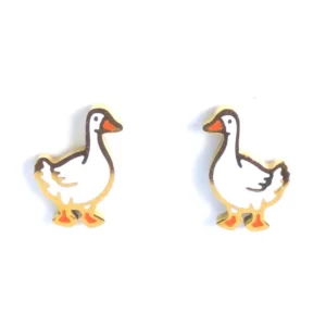 Pair of gold duck-shaped stud earrings with white enamel bodies and bold black outlines. Each duck has orange beaks and feet, facing slightly inward.