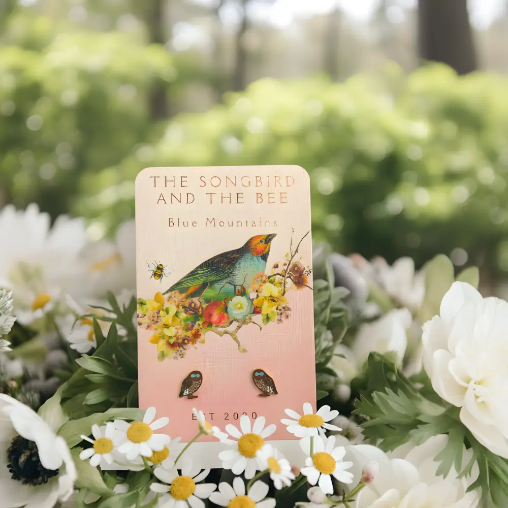 owl gold earrings on a card on a bundle of flowers