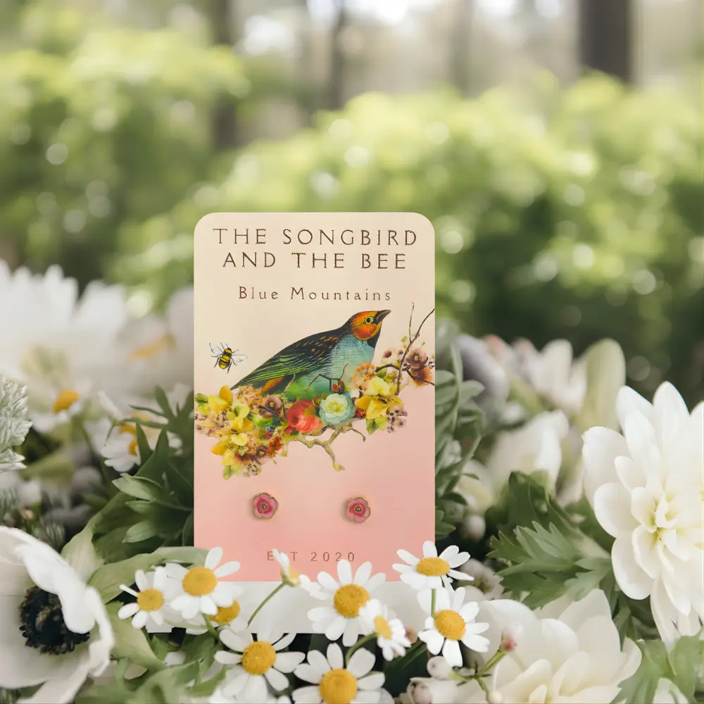 rose gold earrings on a card on a bundle of flowers